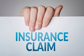 Hand holding insurance claim document