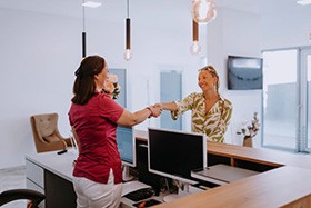 Patient shaking hands with dental team member