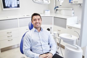 Man sitting in dental chair and smiling