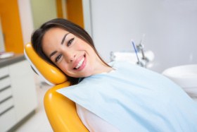 Female dental patient sitting back in chair and smiling